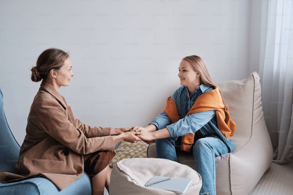 two-women-holding-hands-therapy-office