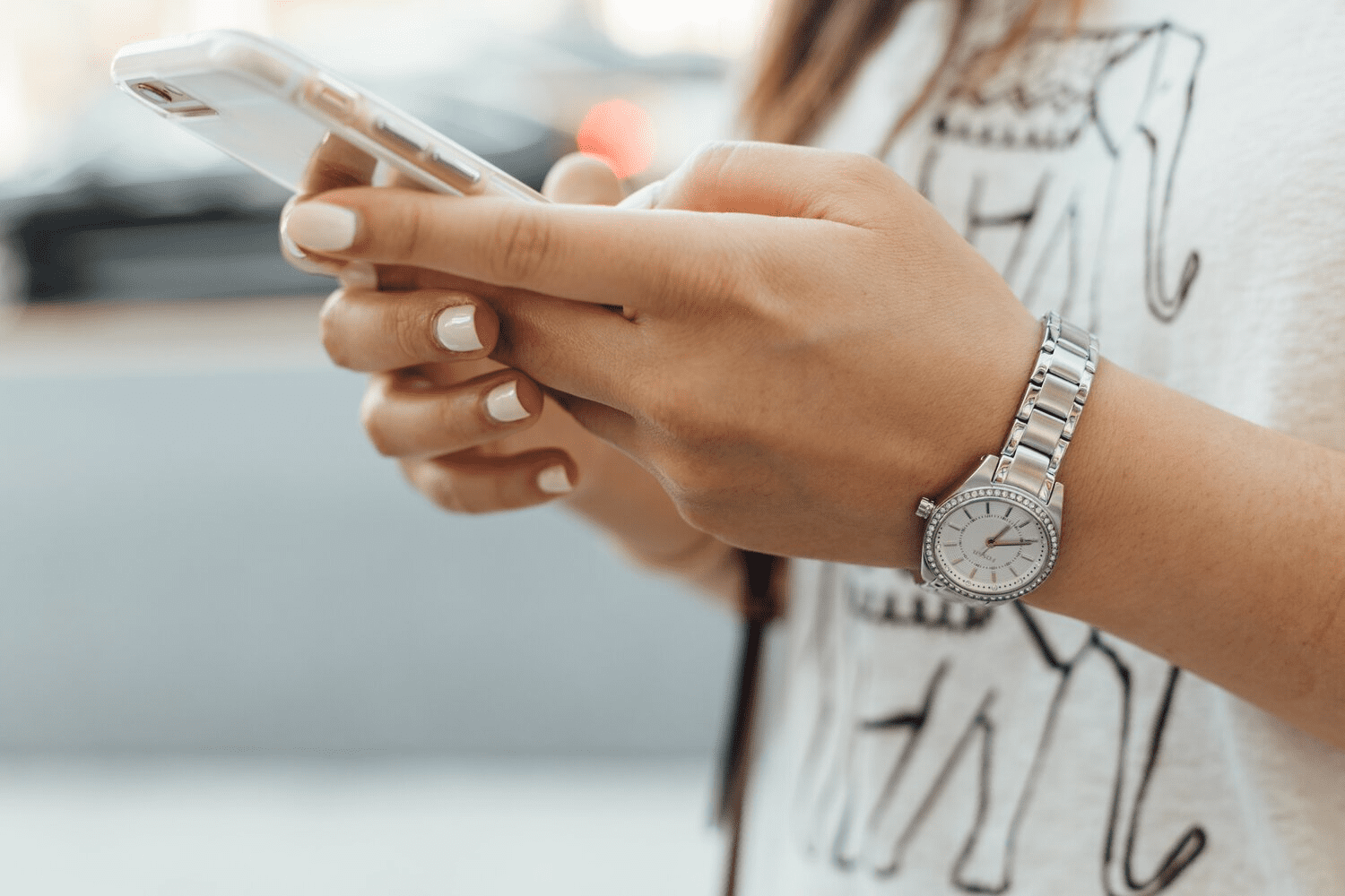 girl-holding-white-iphone-white-nails-white-top-brown-hair