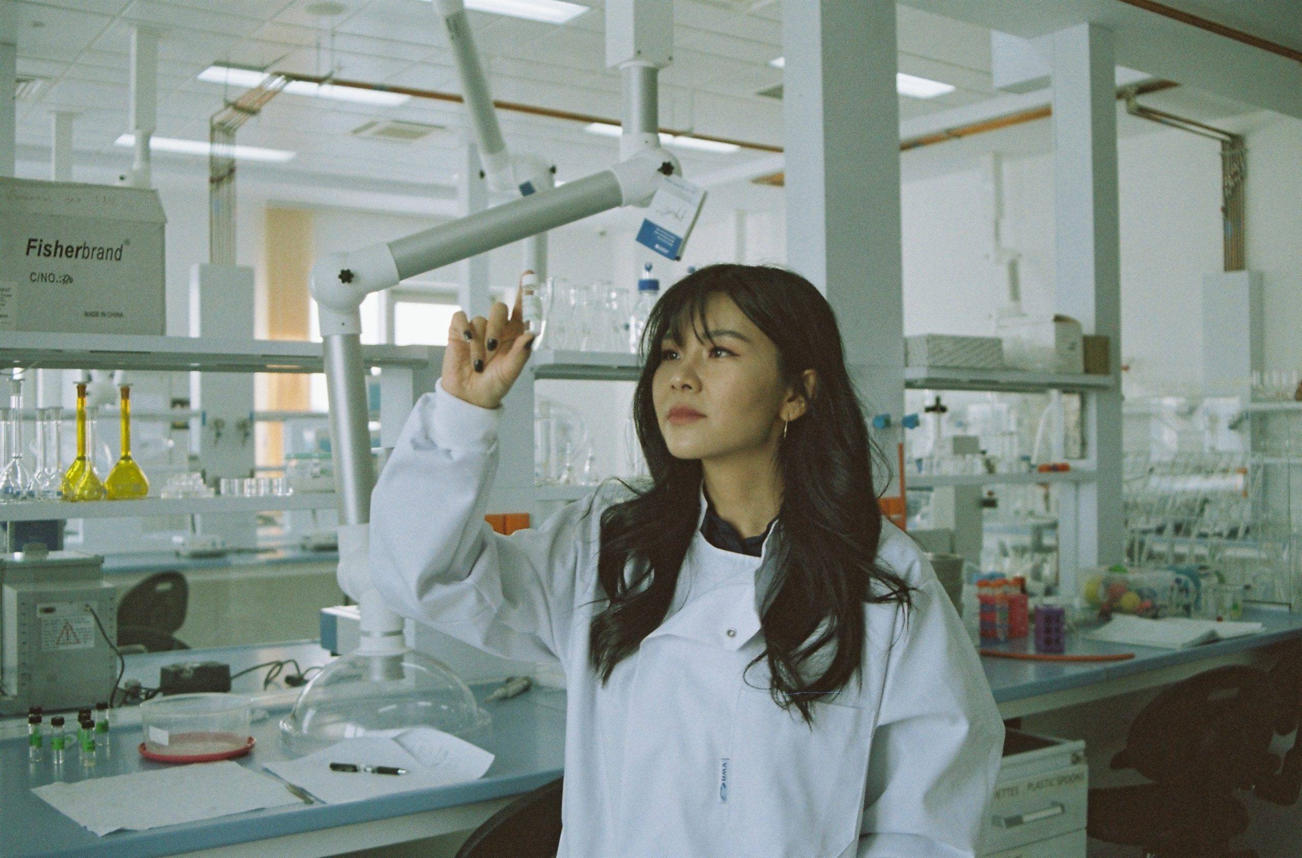 asian-woman-holding-medicinal-fluid-in-lab-white-lab-coat