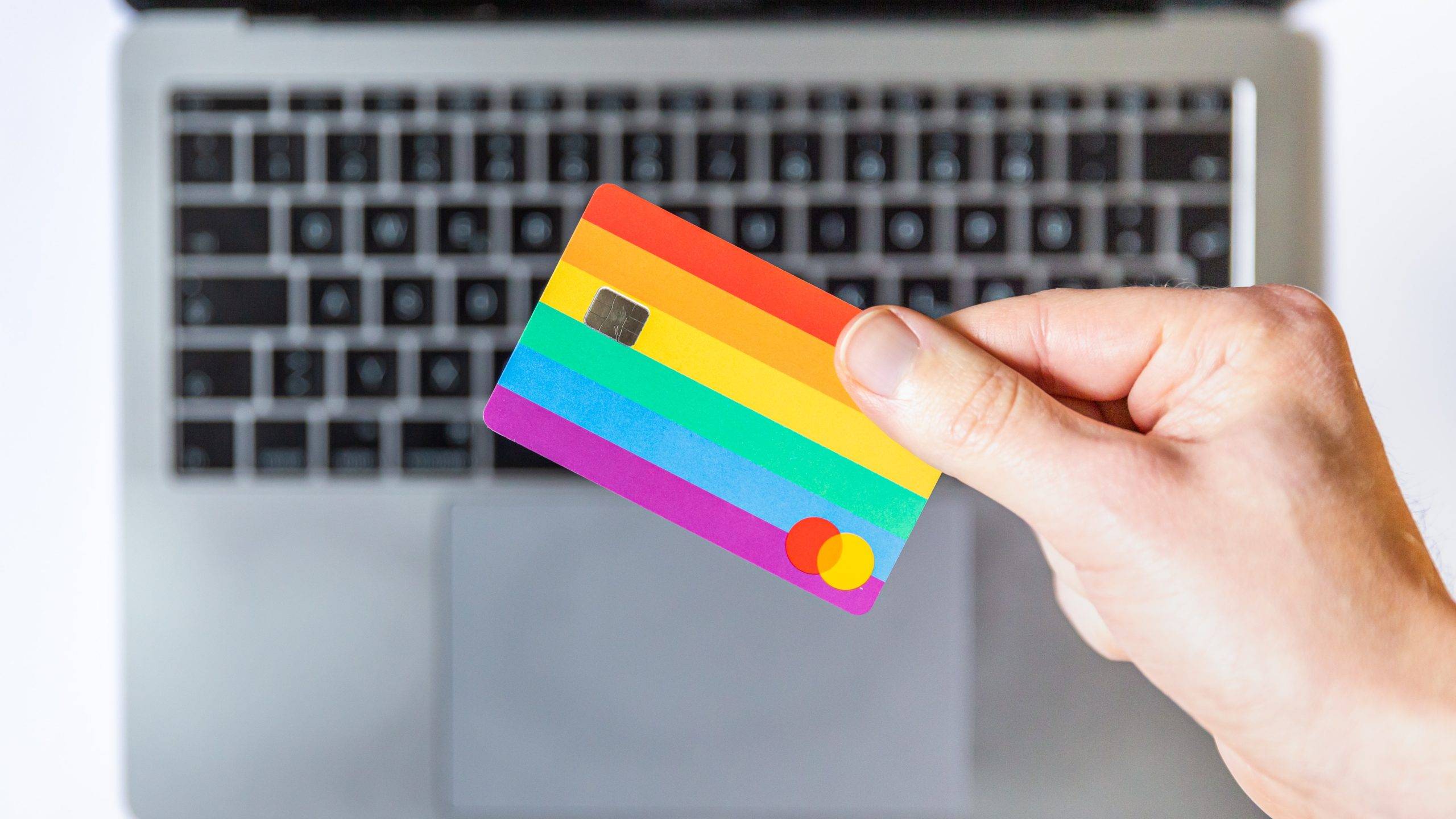 macbook-laptop-background-hand-holding-rainbow-credit-card-risks-to-online-ordering-abortion-pill